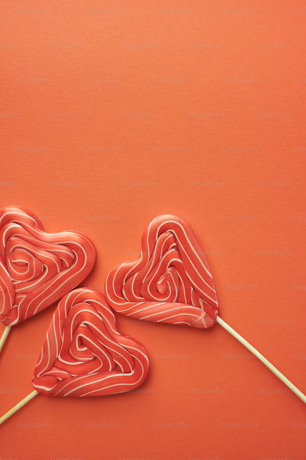 two lollipops shaped like hearts on a stick