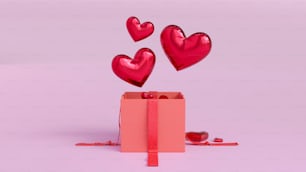 Una caja rosa con corazones flotando fuera de ella
