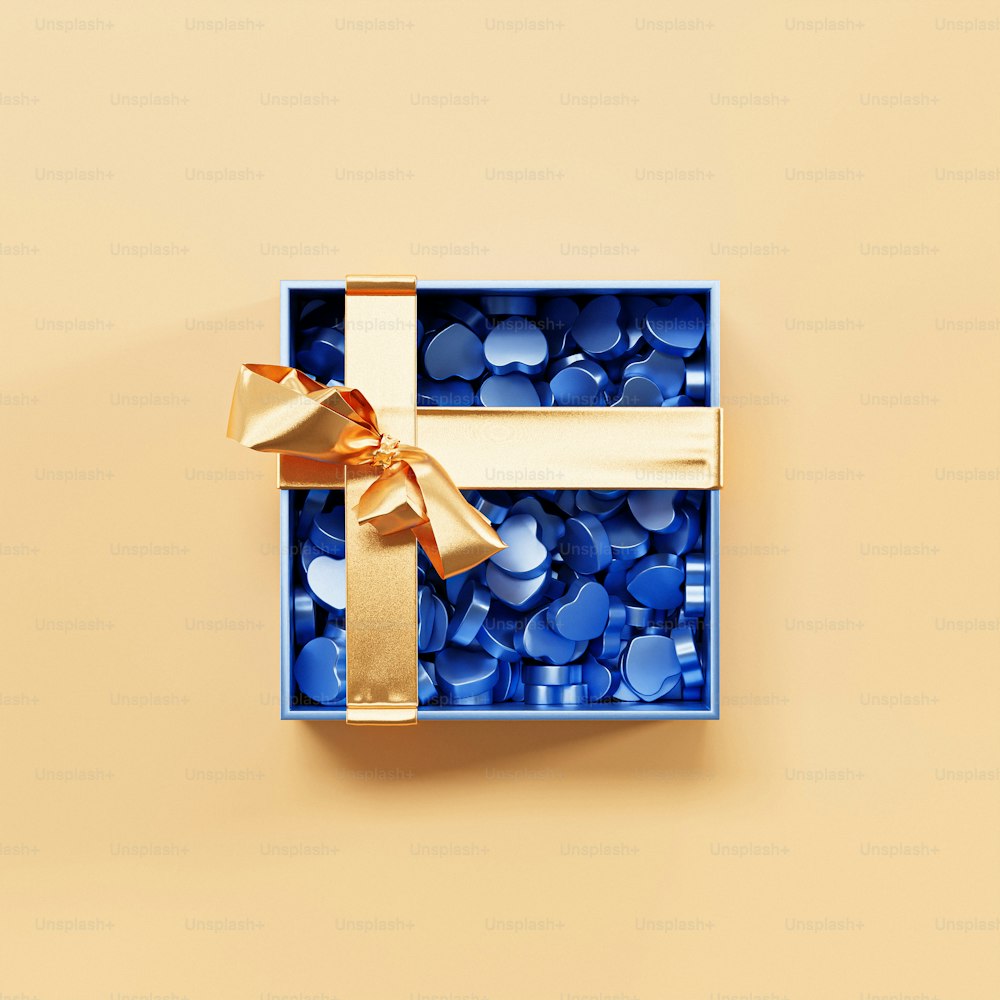 una scatola blu con un nastro d'oro e un fiocco