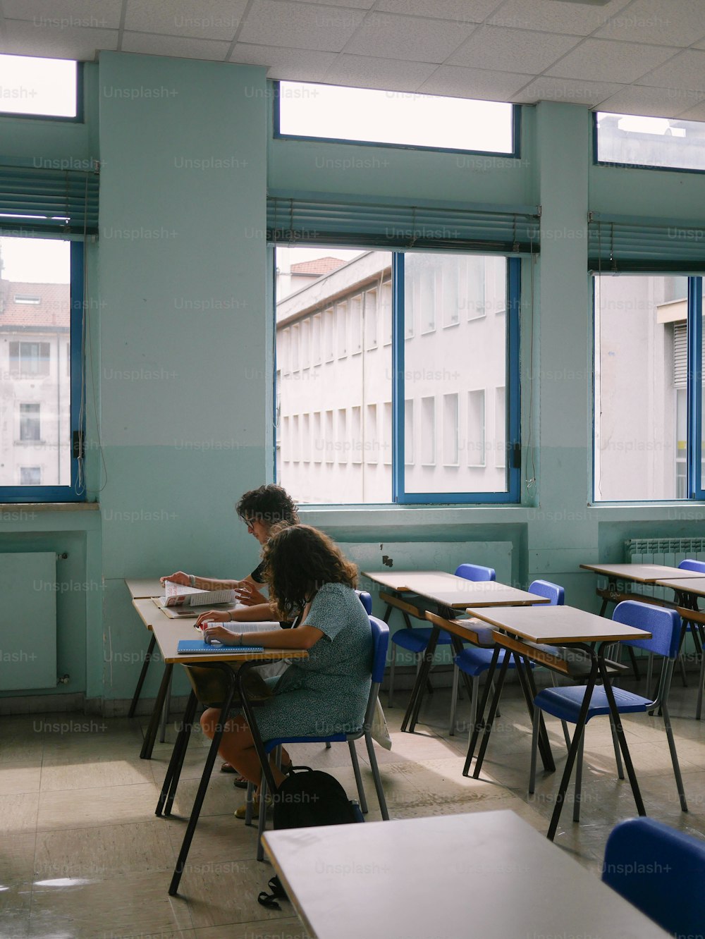 a woman sitting at a desk in a classroom