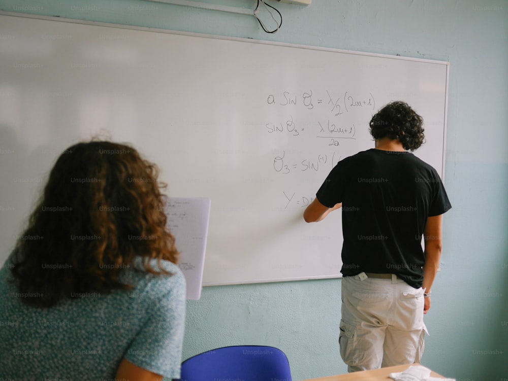 a man and a woman writing on a whiteboard