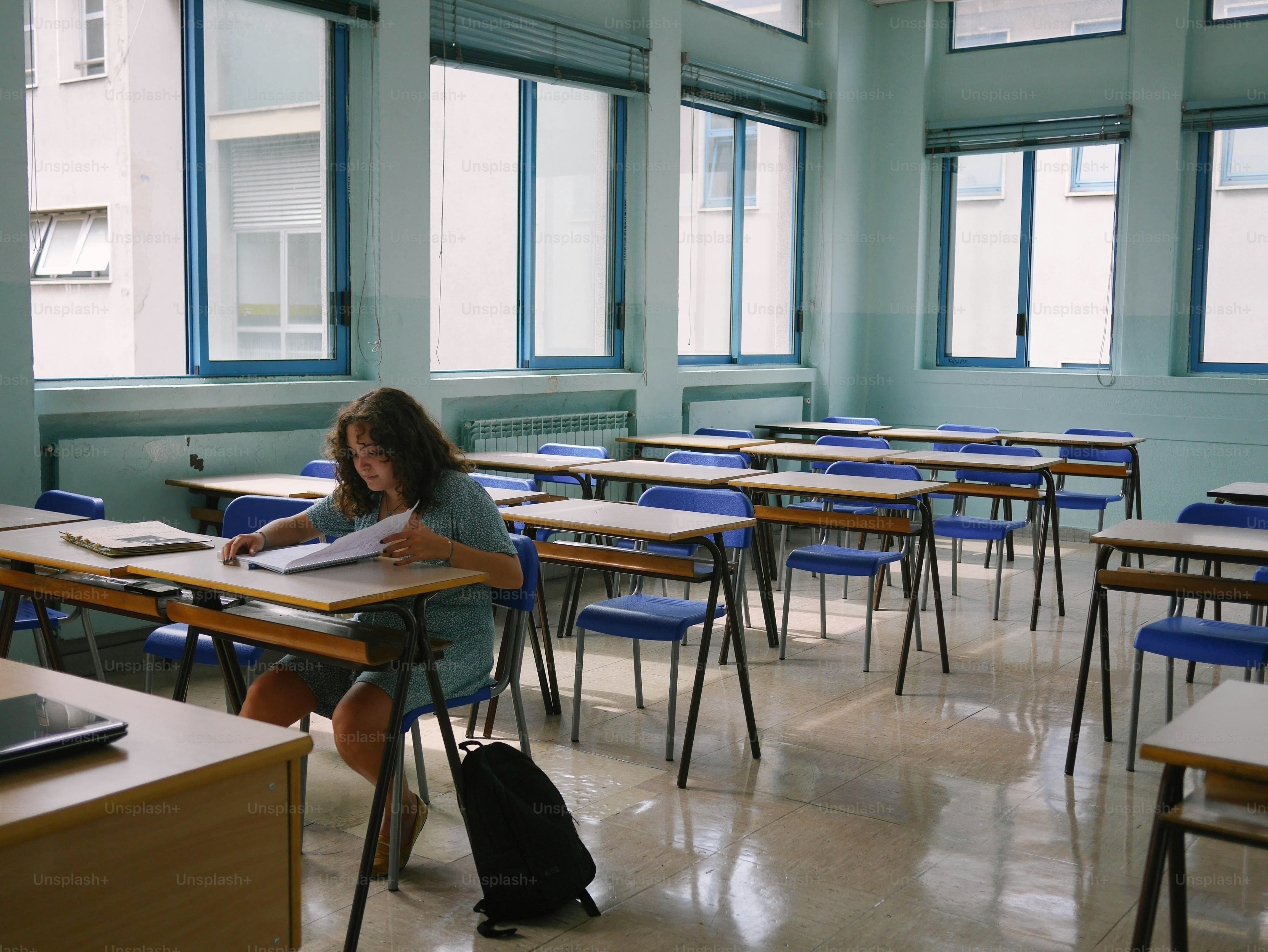 a girl sitting at a desk in a classroom
