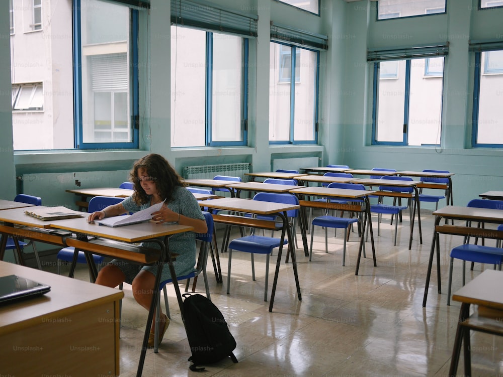 a girl sitting at a desk in a classroom