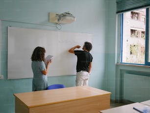 a man and a woman writing on a whiteboard