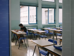 a person sitting at a desk in a classroom