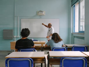 Eine Gruppe von Menschen, die an Schreibtischen in einem Klassenzimmer sitzen