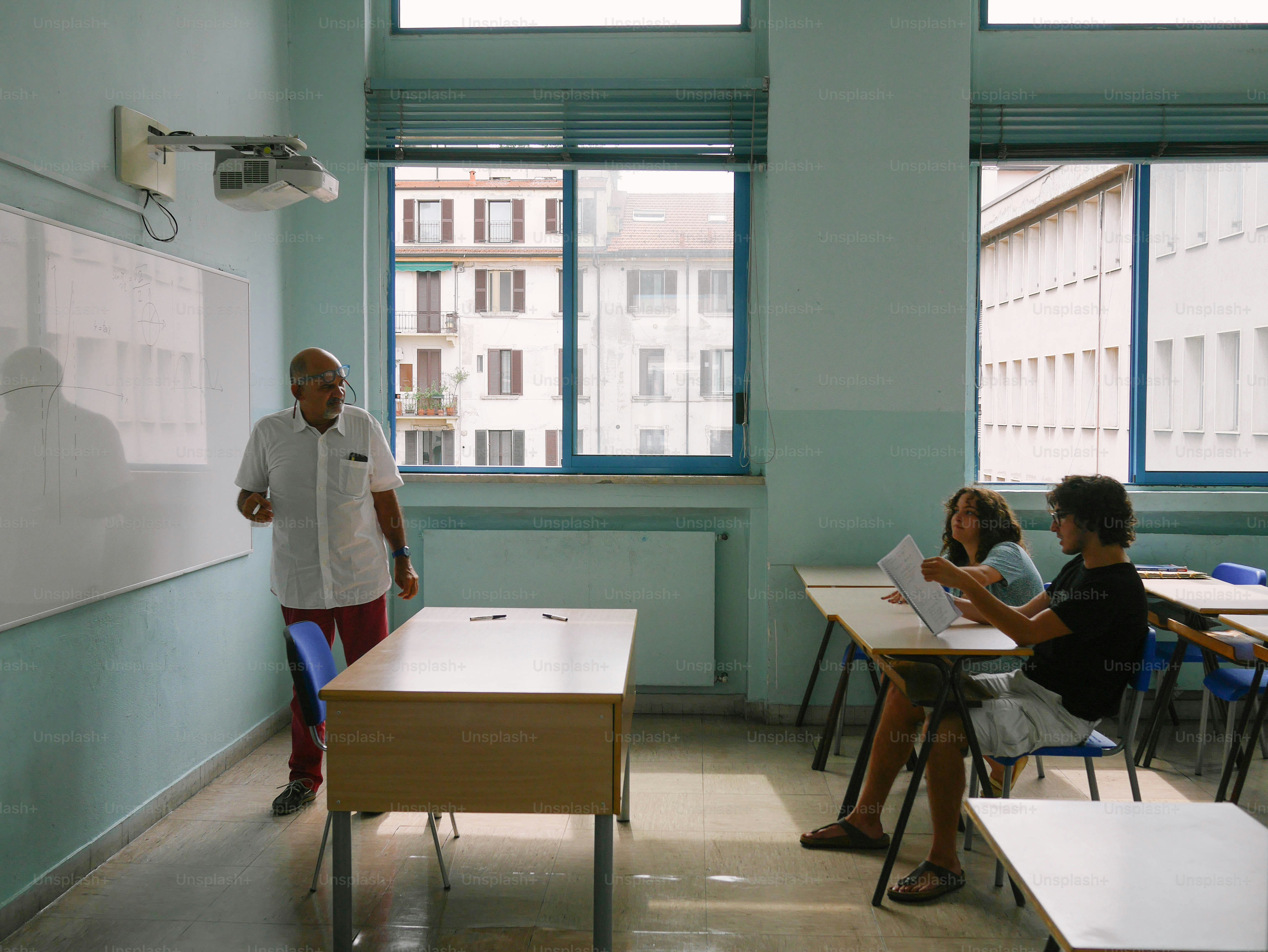 a group of people sitting at desks in a classroom