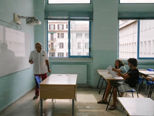 Un grupo de personas sentadas en escritorios en un aula
