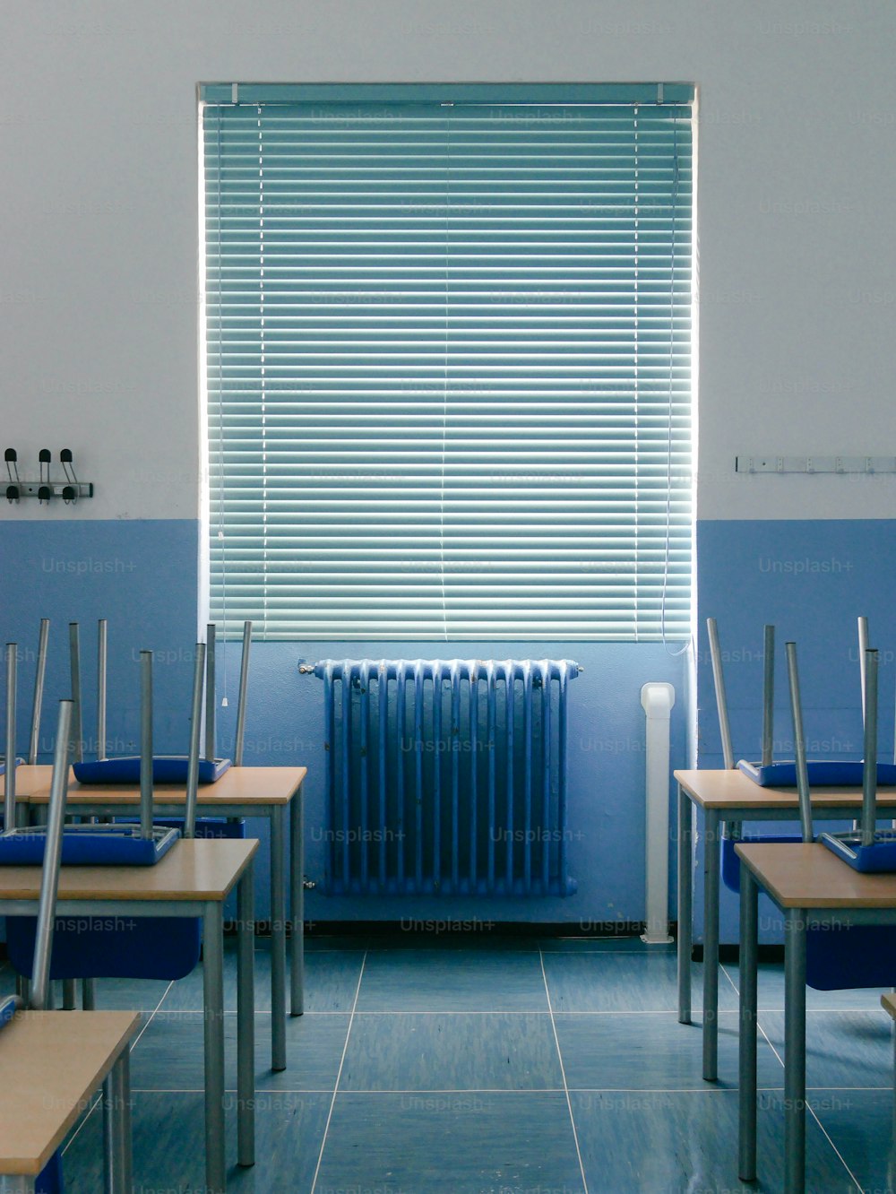 a row of desks in front of a window with a radiator