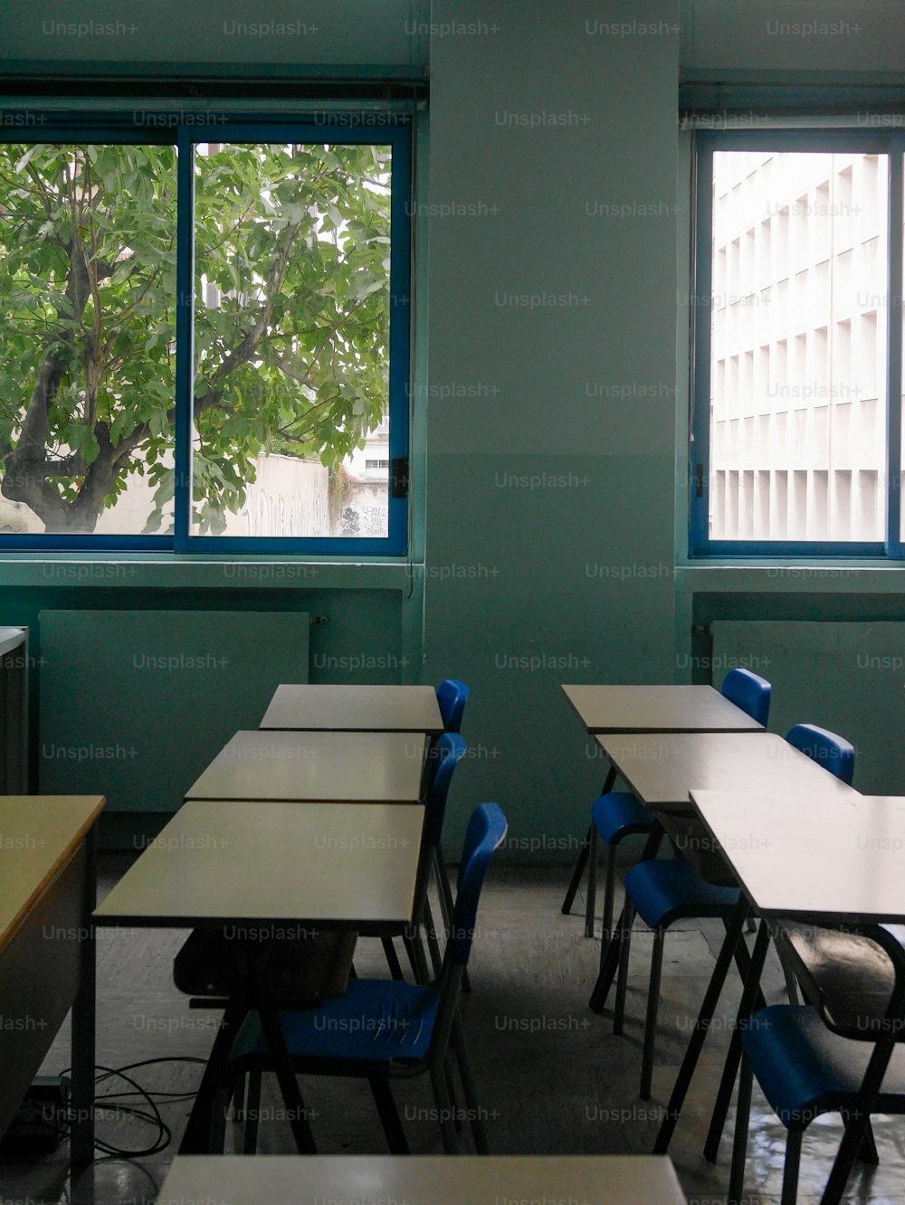 uma sala de aula vazia com carteiras e cadeiras