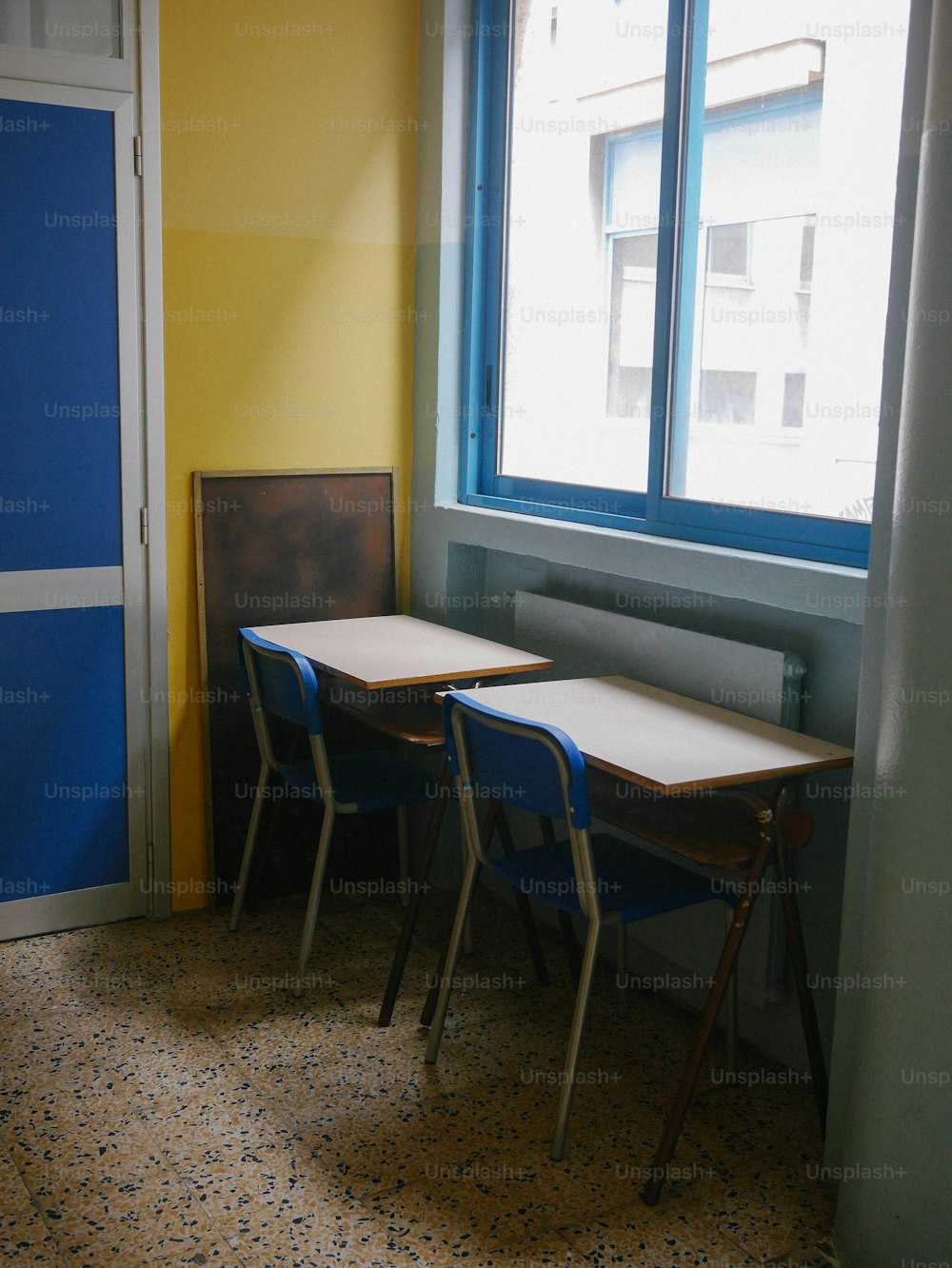 a room with two desks and a window