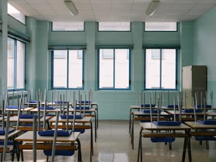 uma sala de aula com fileiras de carteiras e cadeiras