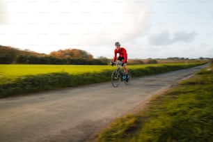 Un uomo che guida una bicicletta lungo una strada di campagna