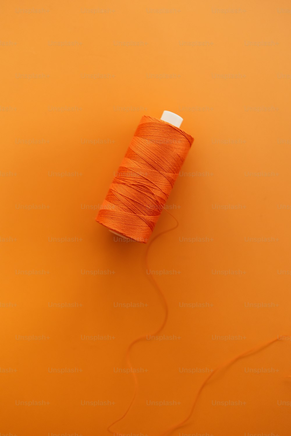 une bobine de fil sur fond orange