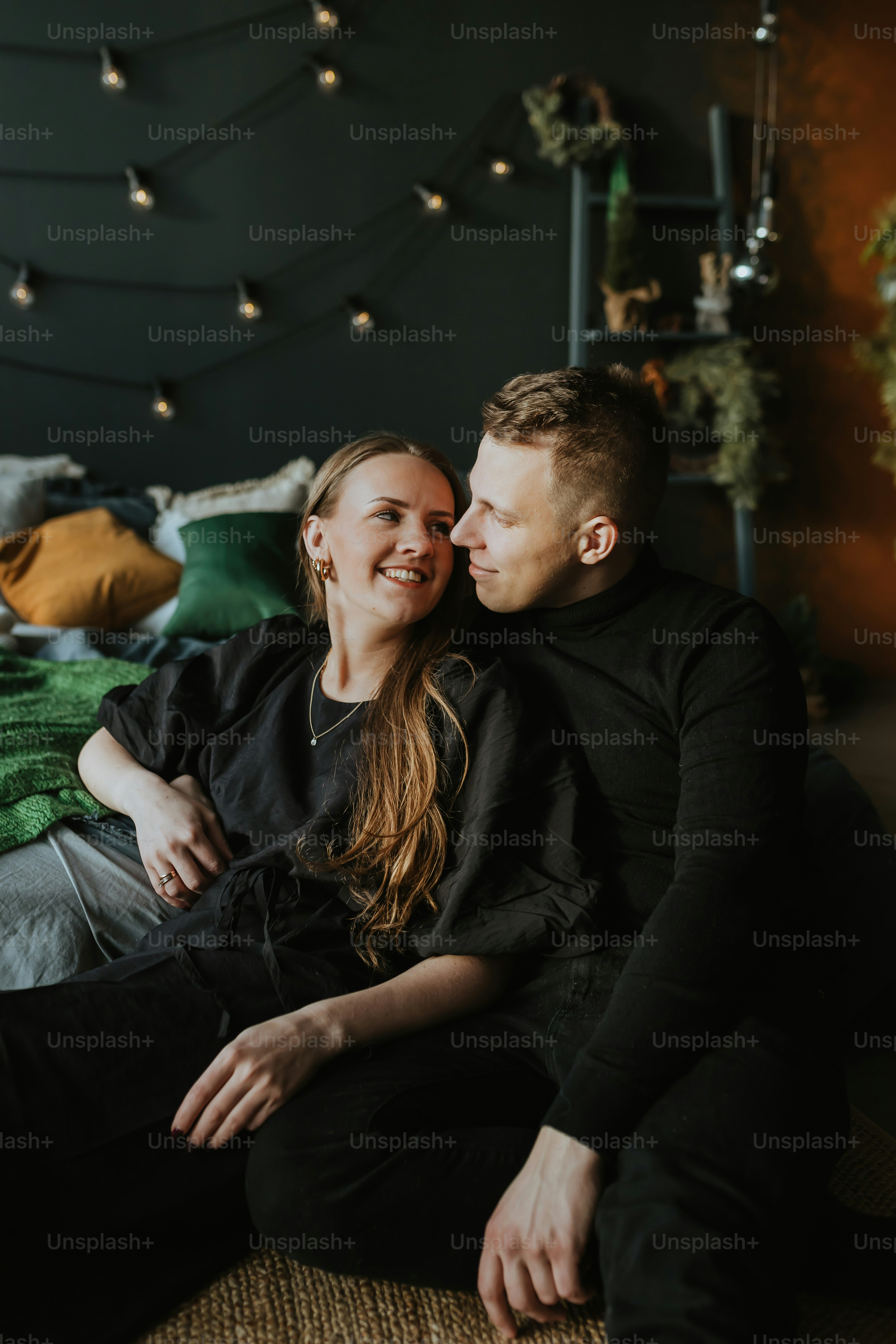 a man and a woman sitting on a bed