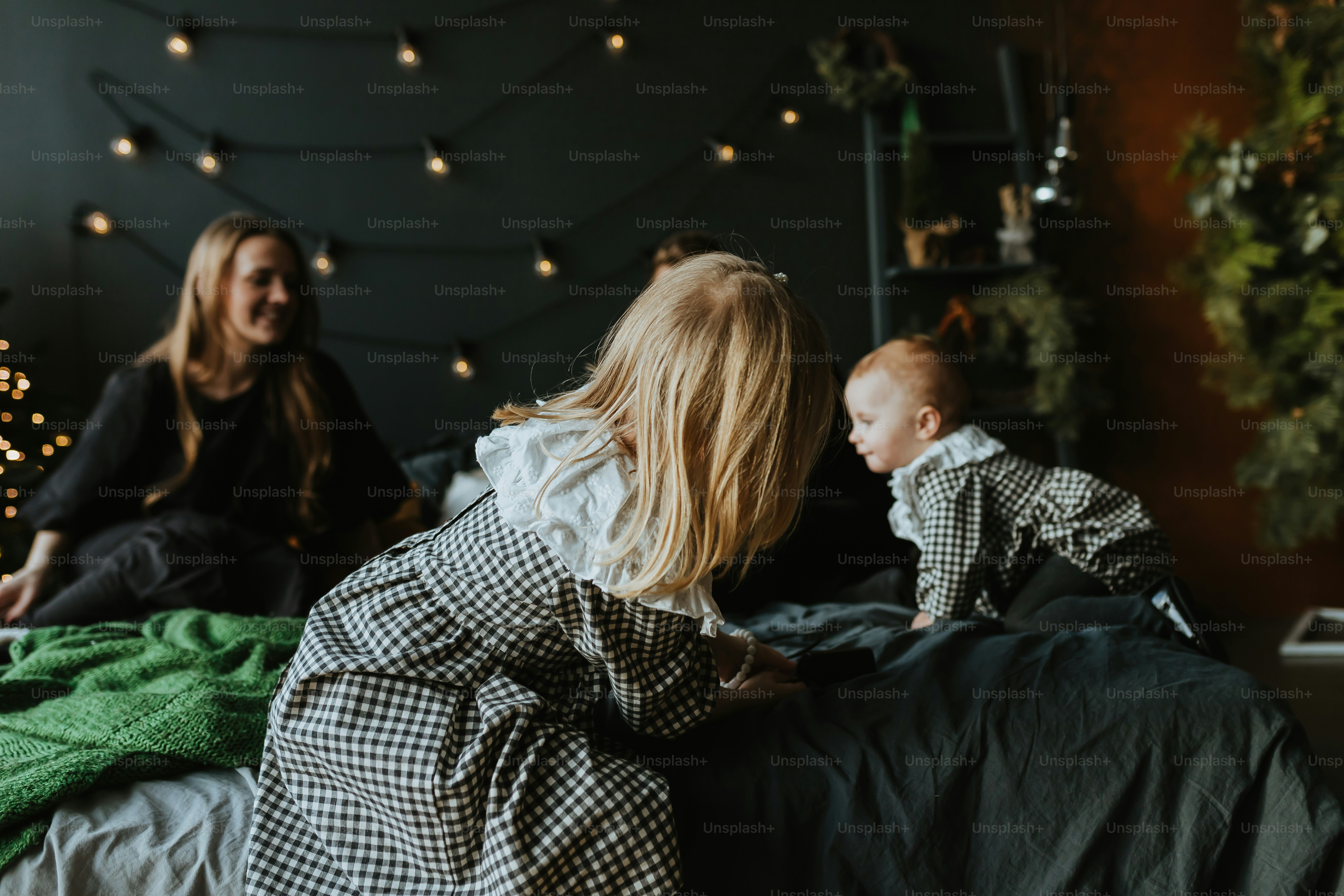 a woman and a baby sitting on a bed