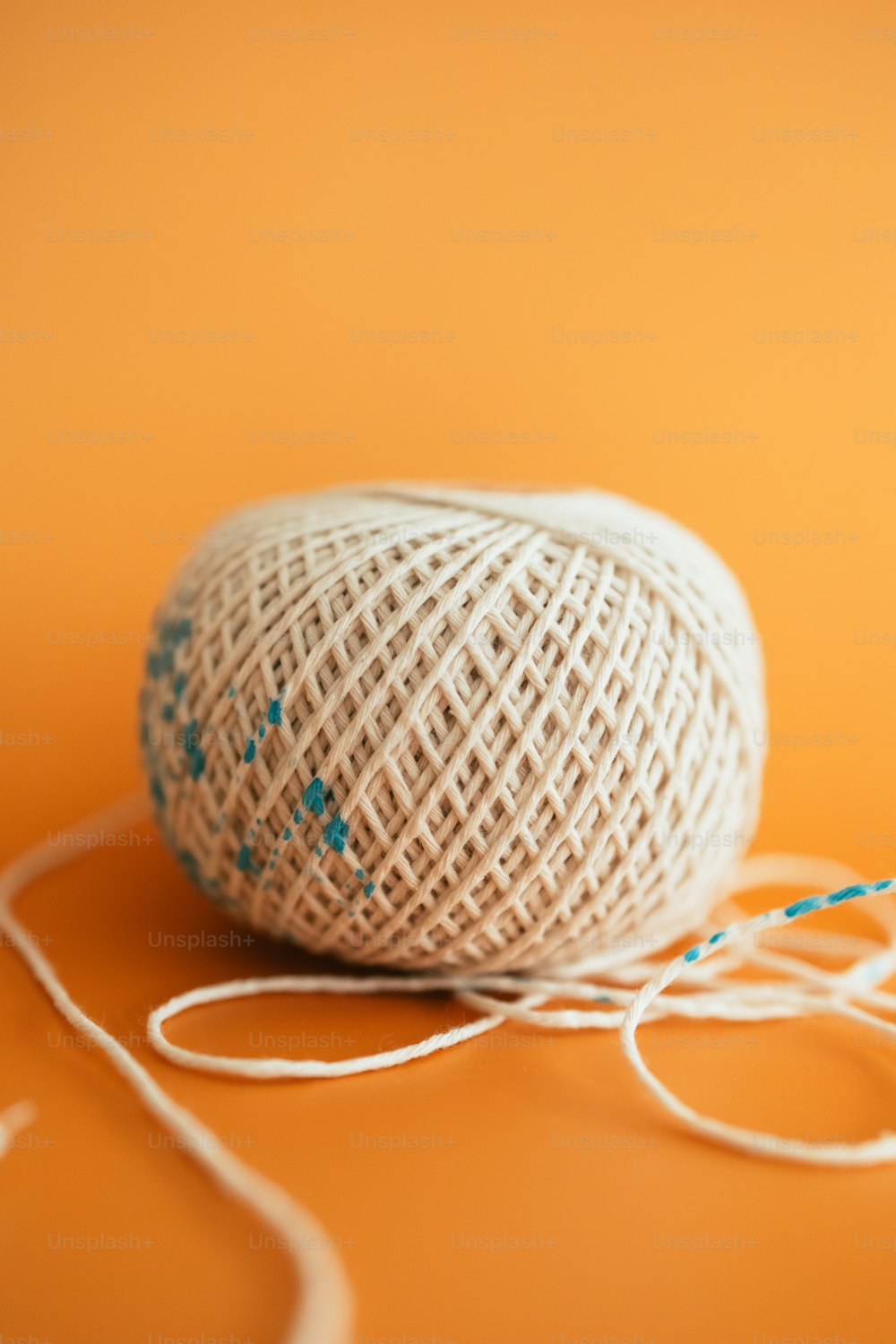 a ball of yarn and a pair of scissors on an orange background