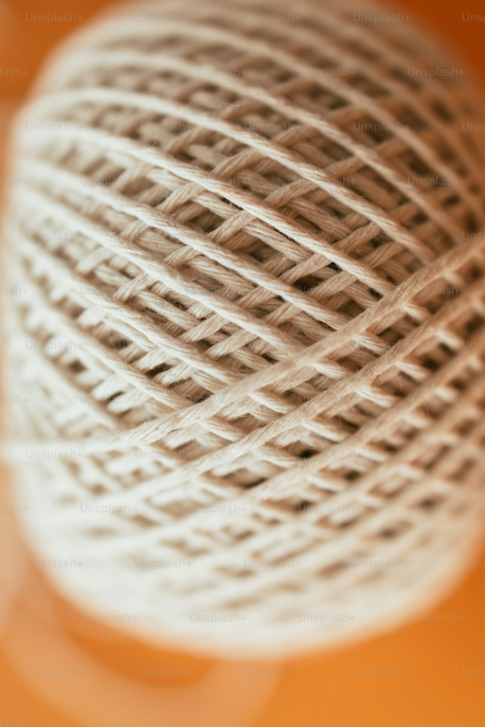 Una bola de hilo blanco sentada encima de una mesa