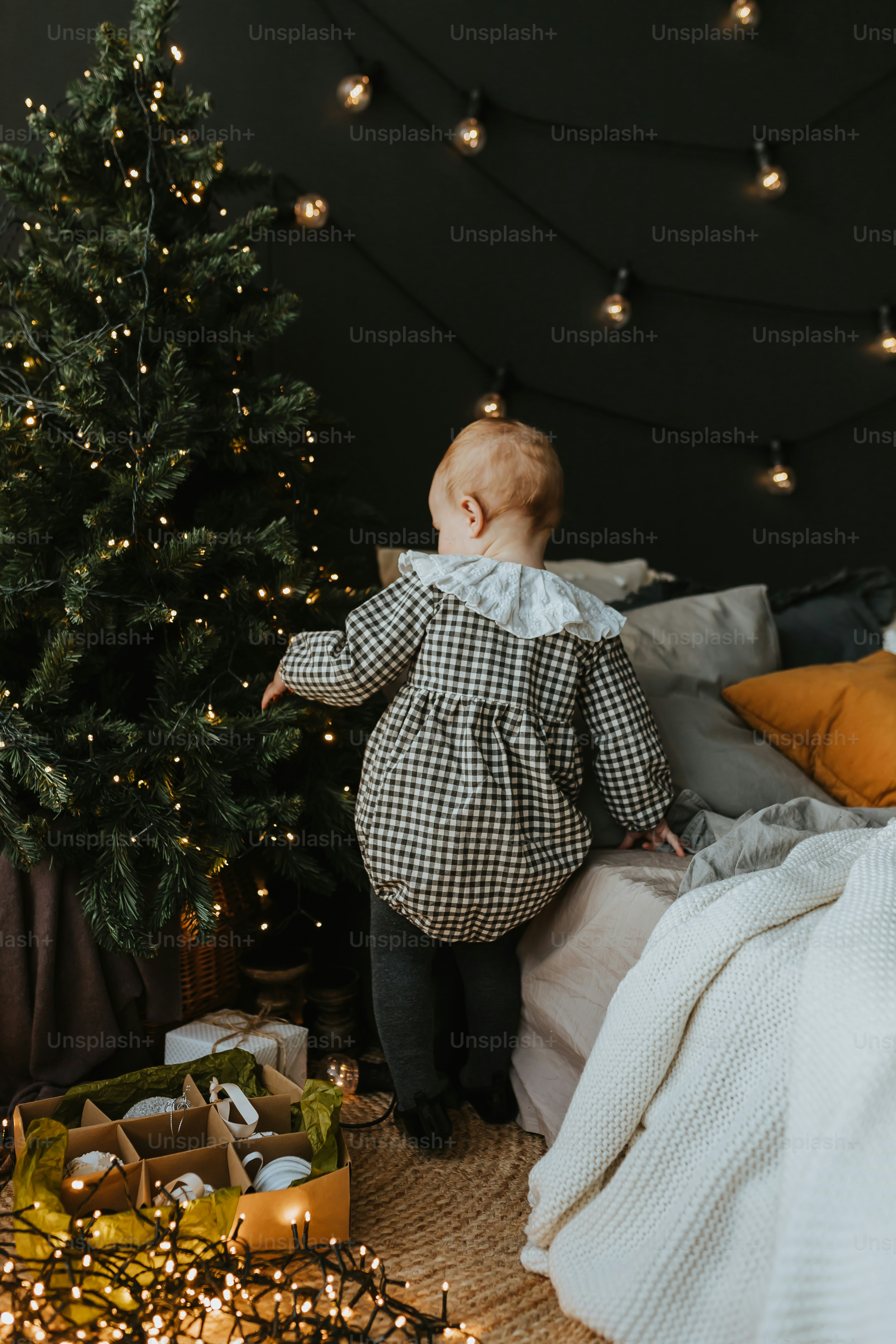 クリスマスツリーの前に立つ3人家族の写真 – Unsplashのクリスマスの画像