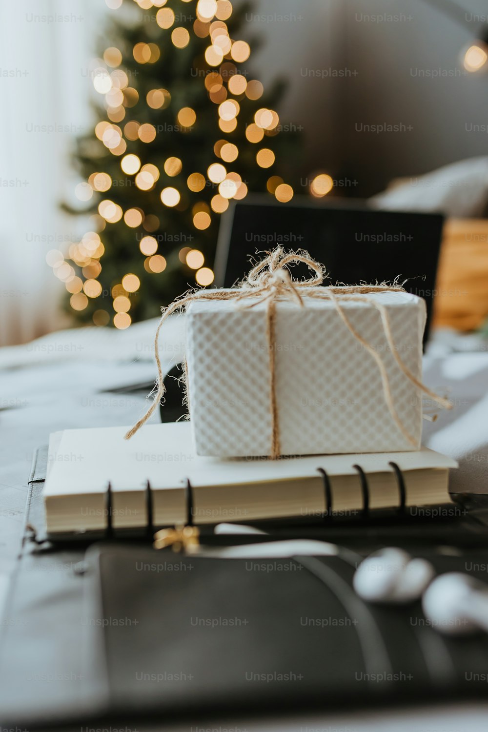 a white present sitting on top of a book next to a christmas tree