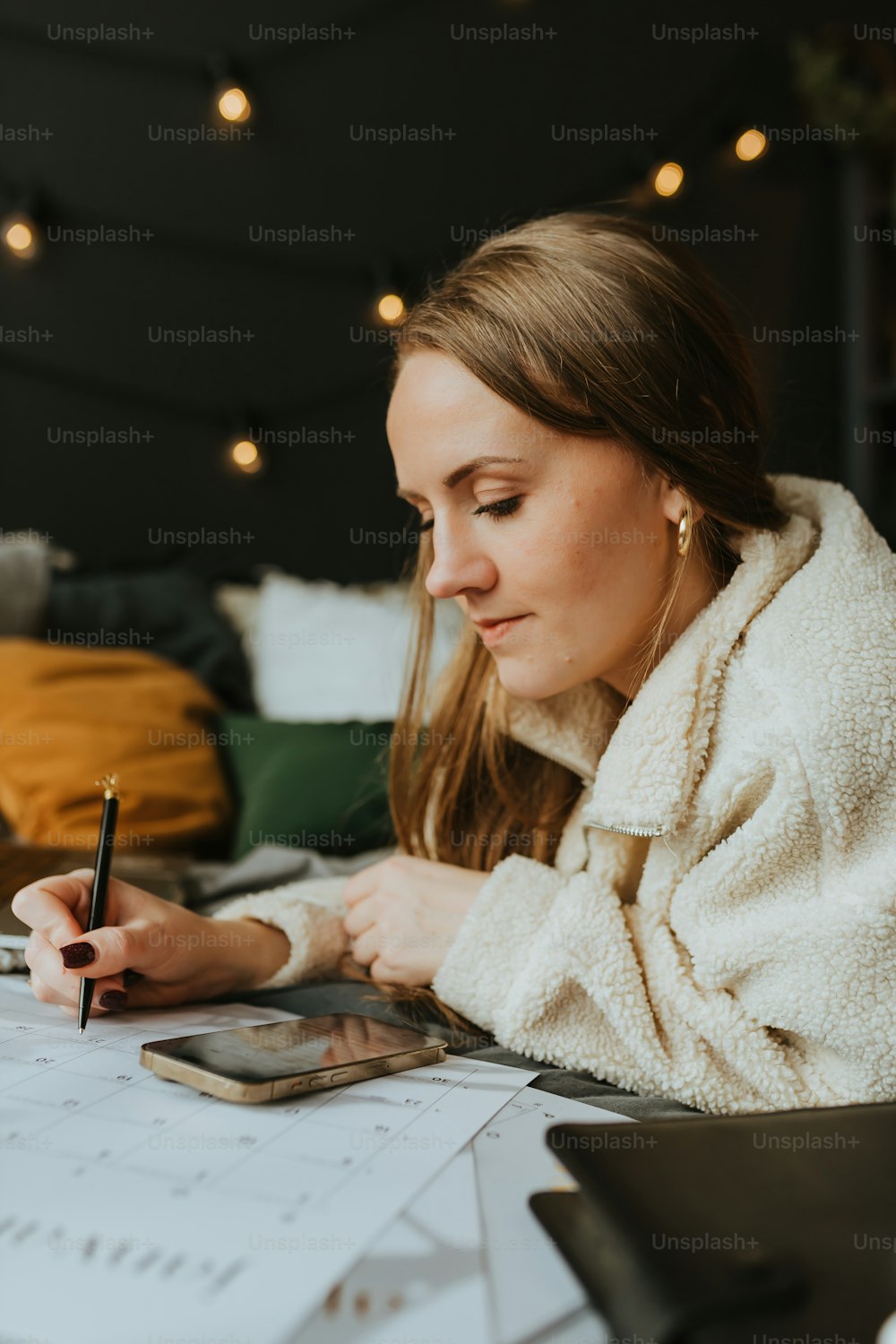 a woman sitting at a desk writing on a piece of paper