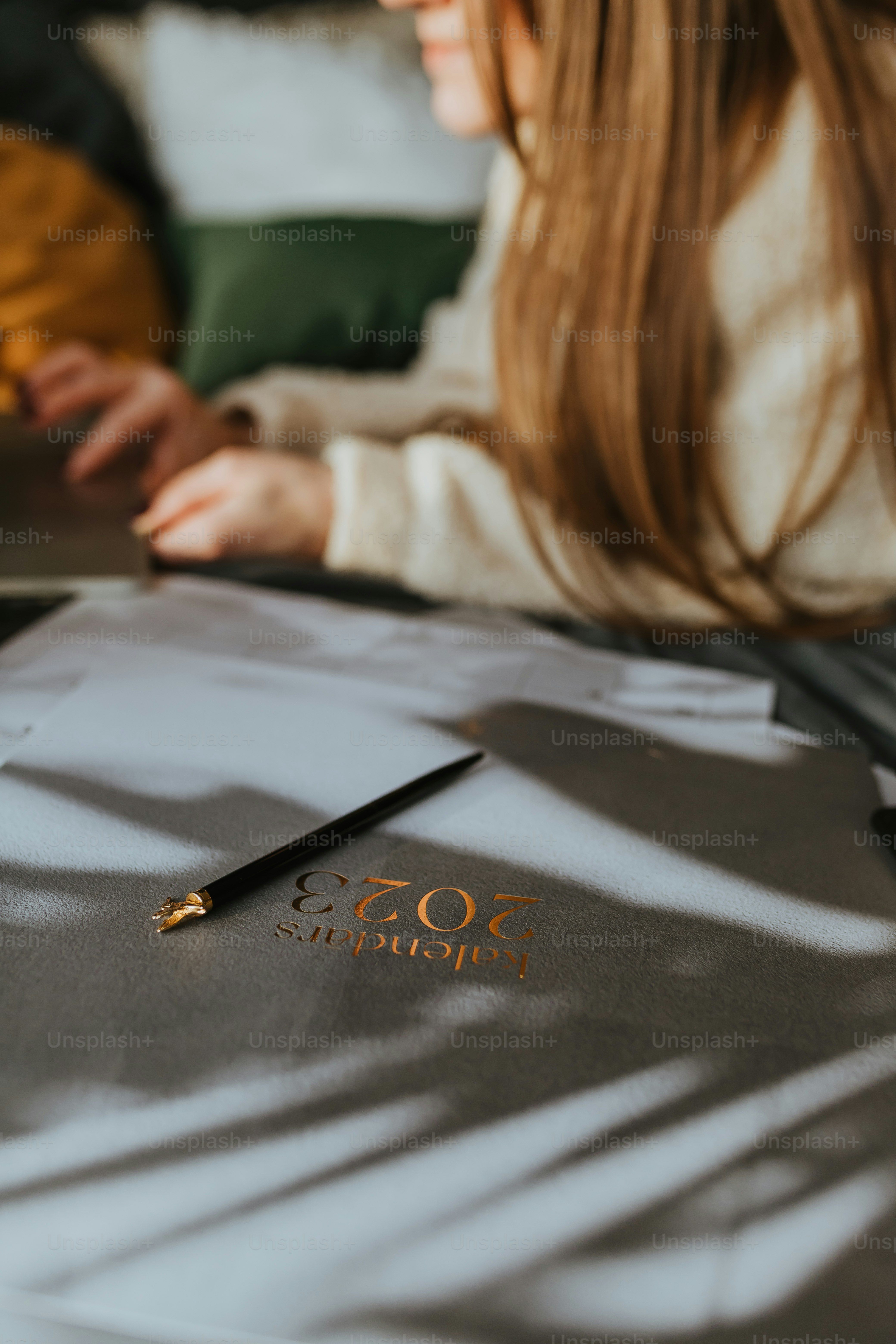 uma mulher sentada em uma mesa com um caderno e caneta