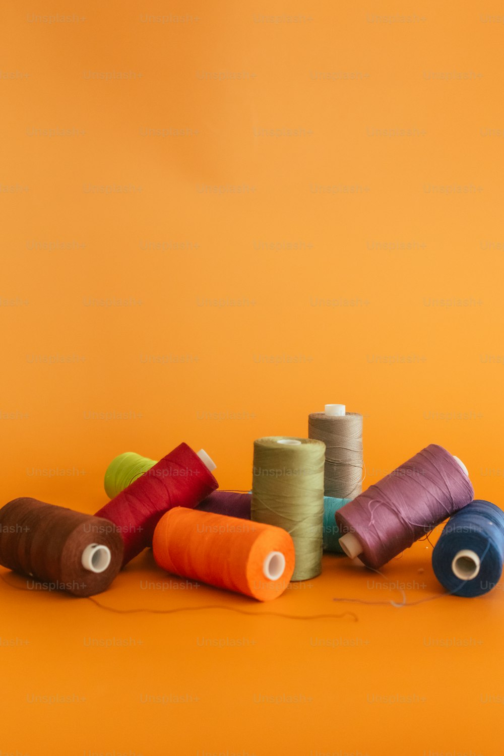 a group of spools of thread on a yellow background