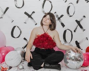 a woman sitting on the floor with a disco ball