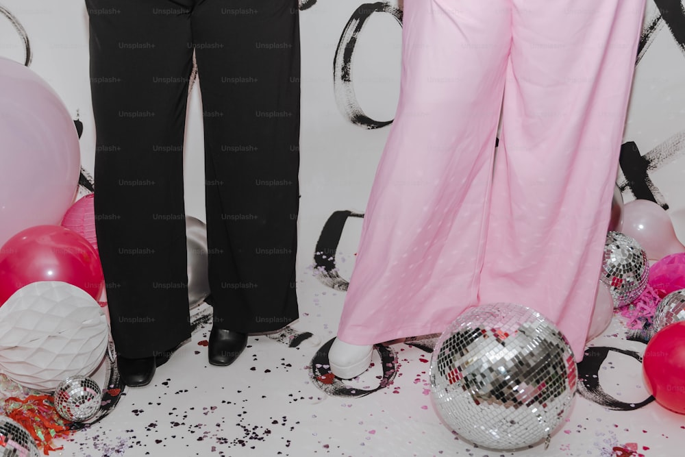 two women standing next to each other in front of balloons and disco balls