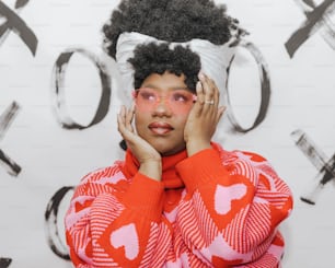 a woman in a red and white sweater holding her hands to her face