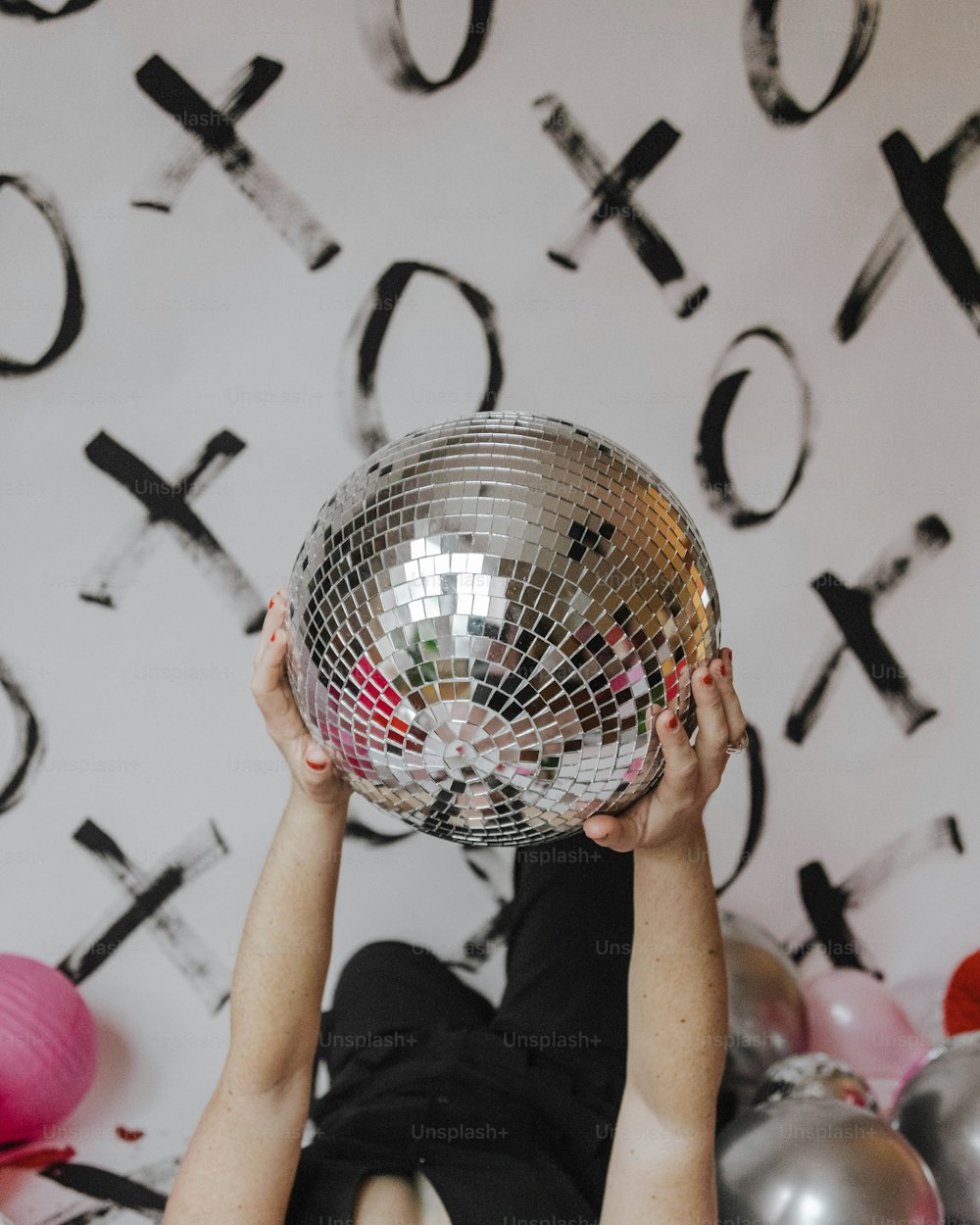 une personne tenant une boule disco au-dessus de sa tête