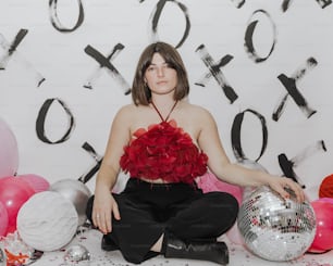 a woman sitting on the floor with a disco ball in front of her
