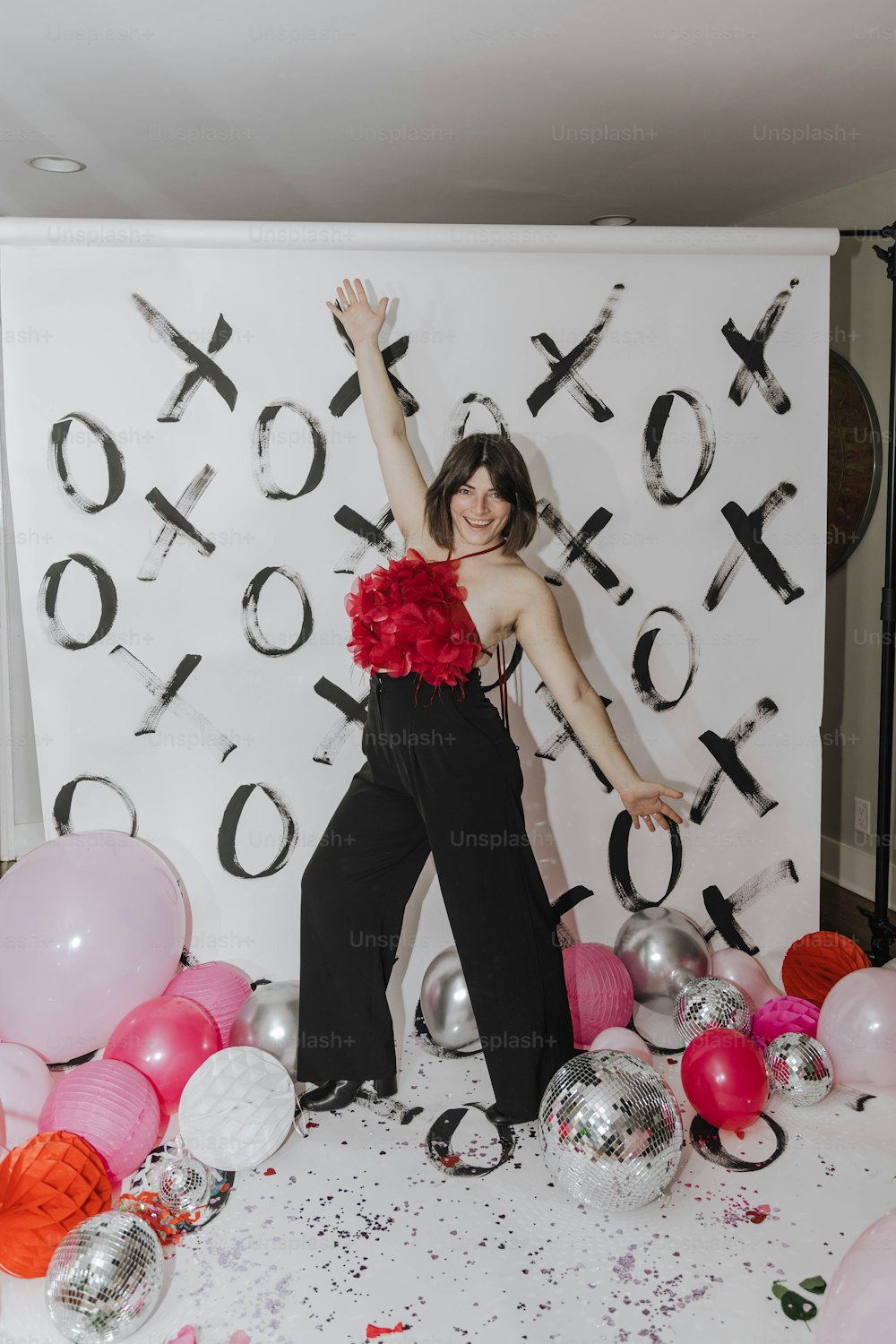 a woman standing in front of a backdrop with balloons