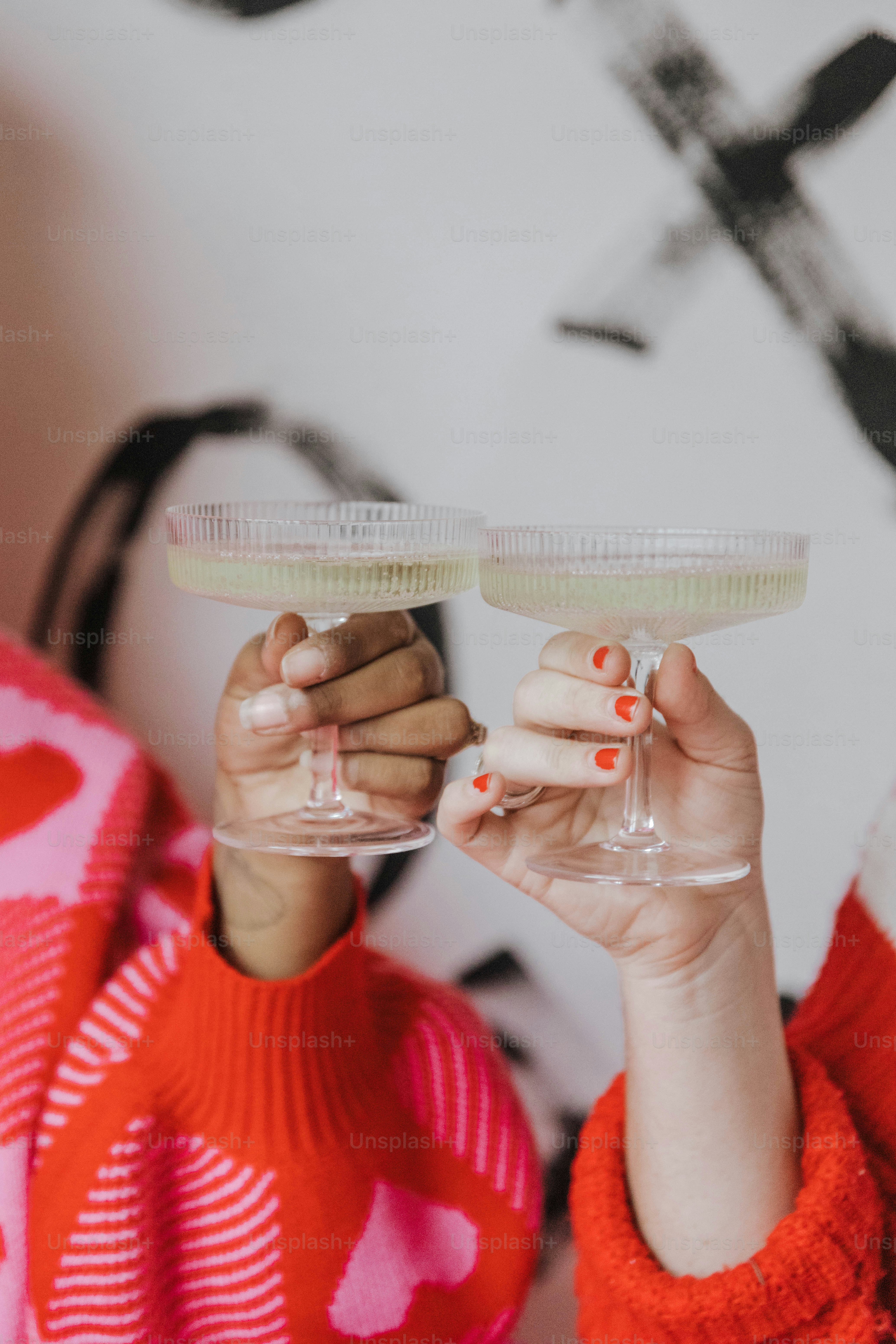 Una mujer sosteniendo una copa de vino en la mano