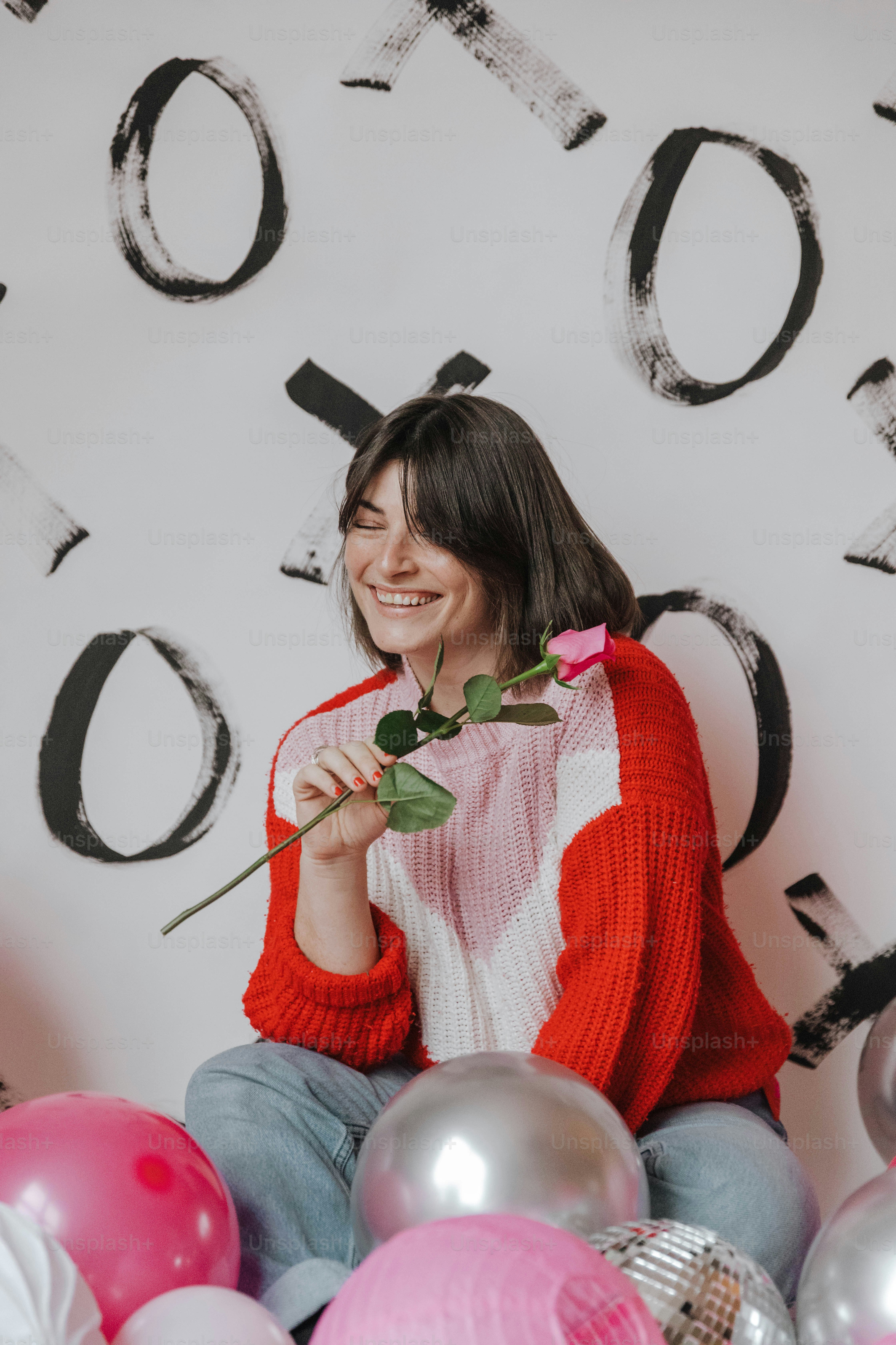 a woman sitting on the floor holding a rose