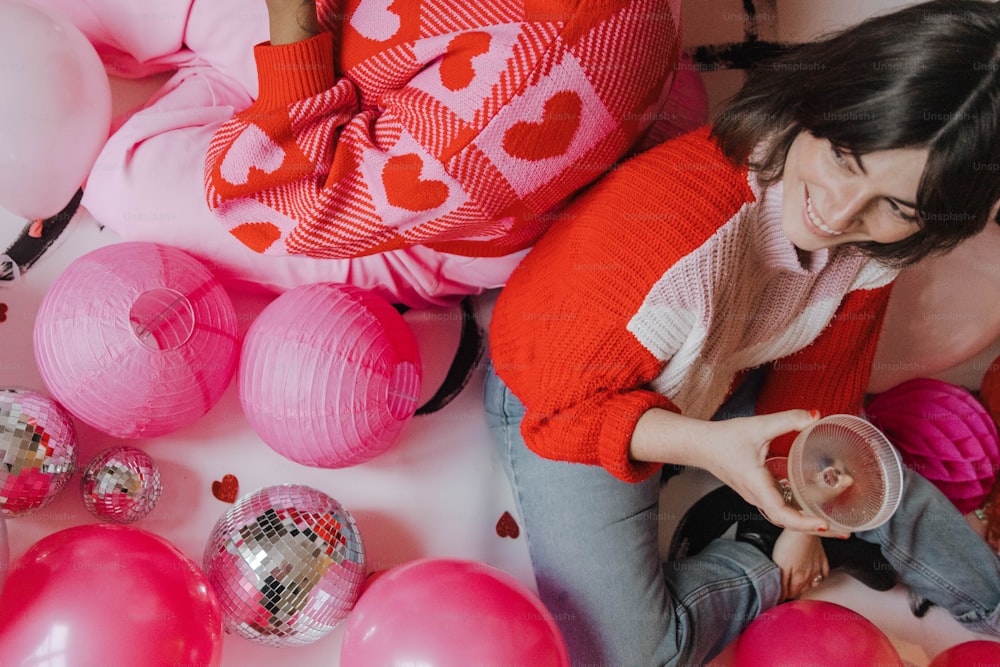 a woman sitting on the floor surrounded by balloons