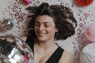 a woman laying on the floor next to a disco ball