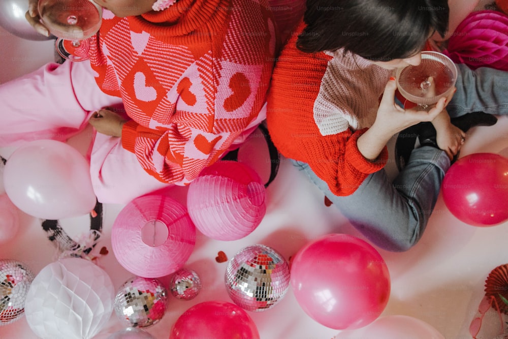 two girls are surrounded by balloons and balloons
