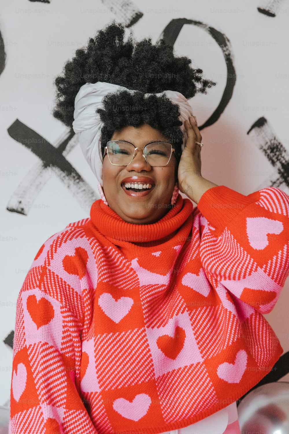 a woman wearing a red and white sweater with hearts on it