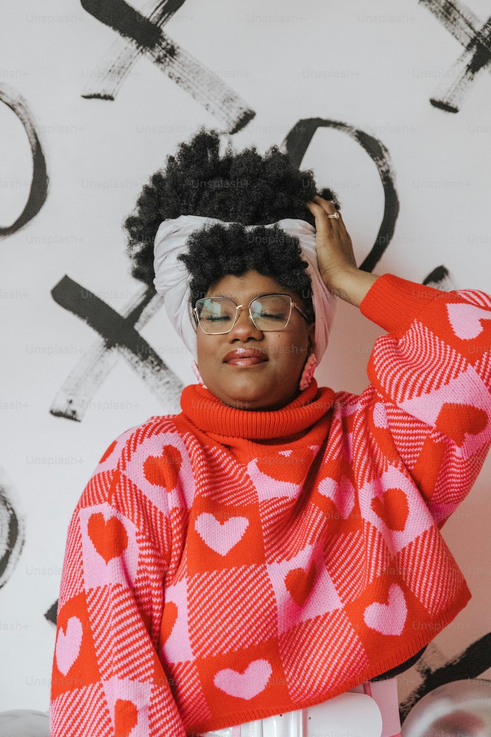 a woman wearing a red and white sweater with hearts on it