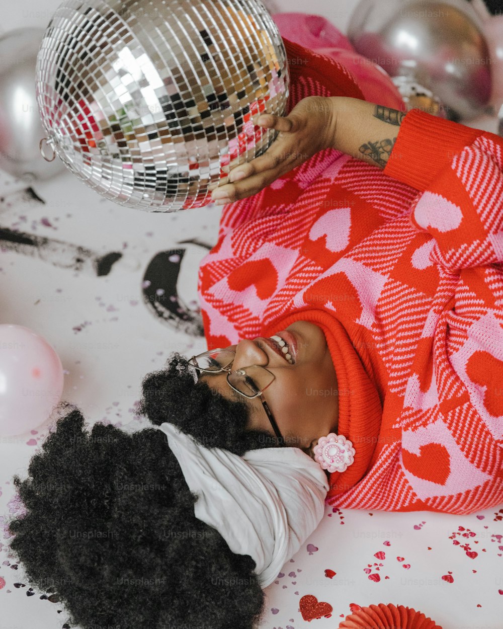 a woman laying on the ground with a disco ball