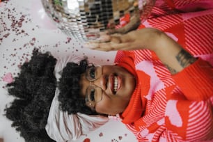 Une femme en robe rouge et blanche tenant une boule disco