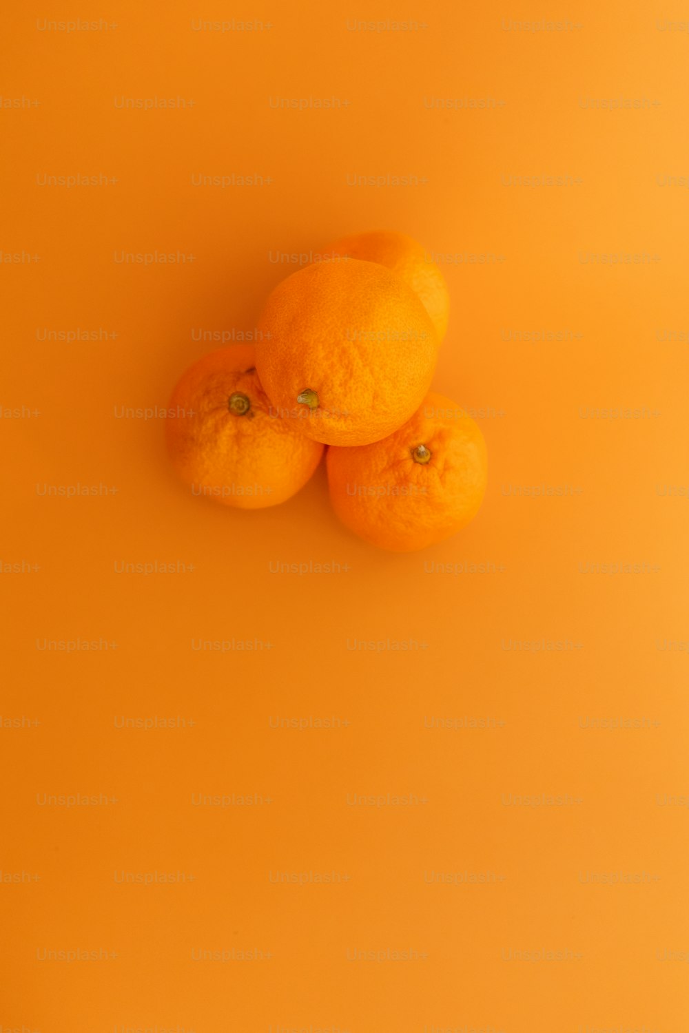 노란색 표면 위에 앉아있는 �세 개의 오렌지