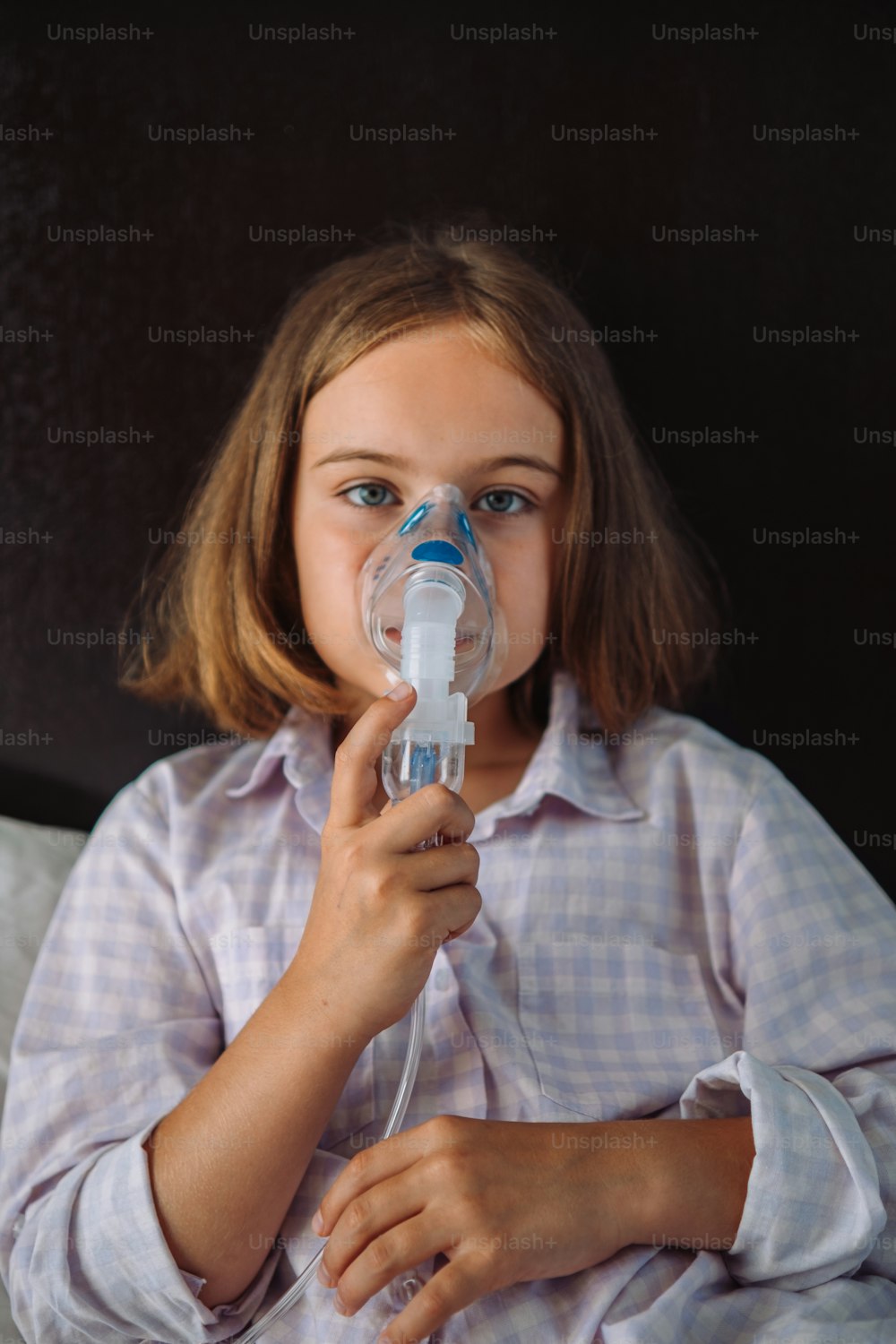 Una niña con un dispositivo de respiración en la boca