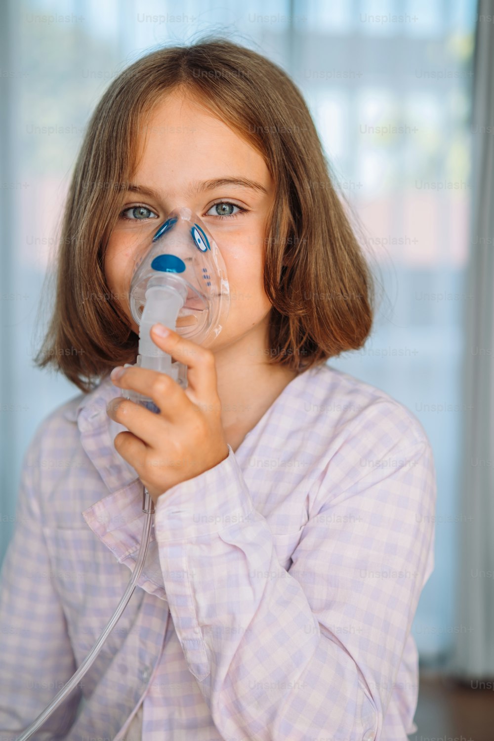 a little girl holding a breathing device in her mouth