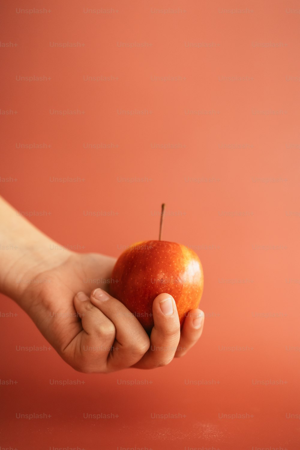 una persona che tiene una mela in mano