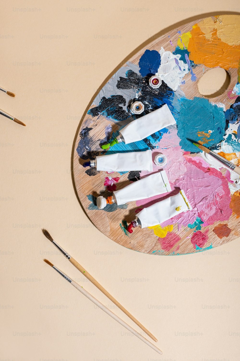 Une palette avec de la peinture et des pinceaux sur une table