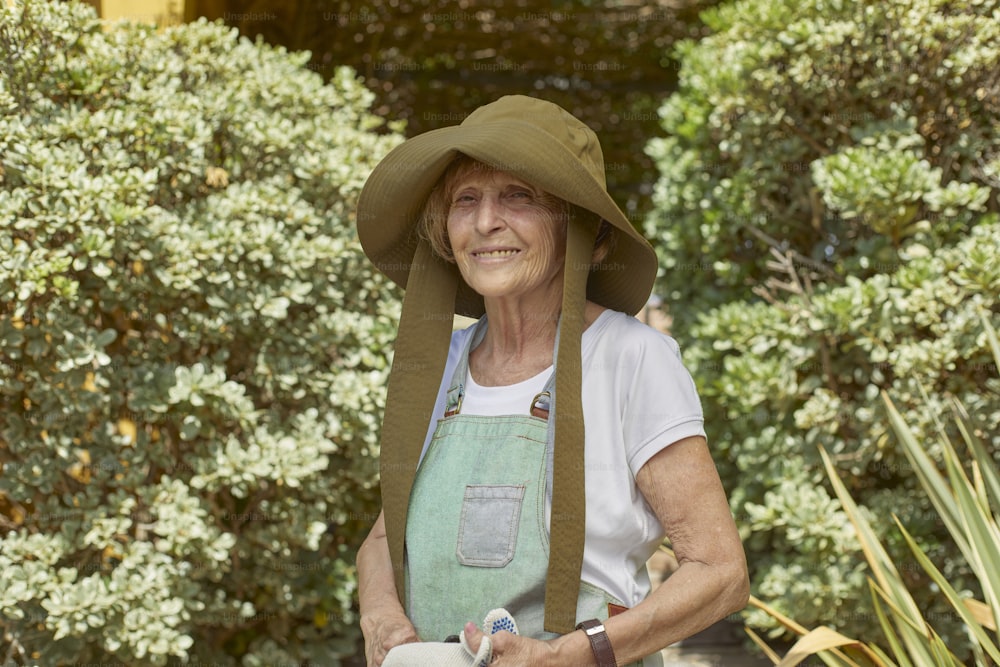 eine ältere Frau mit grünem Hut und Schürze
