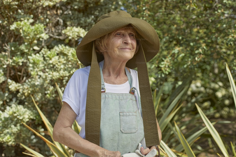 eine ältere Frau mit grünem Hut und Schürze