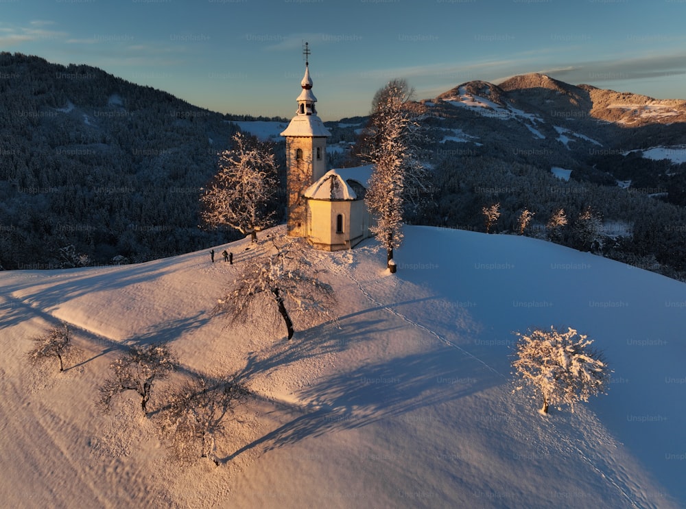 uma igreja no topo de uma colina coberta de neve